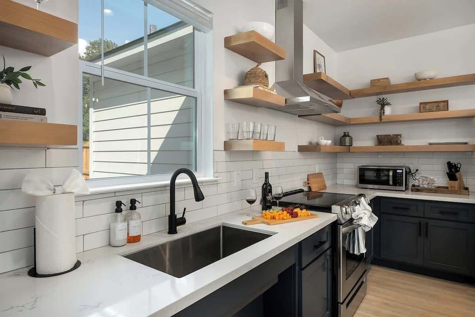 Large farmhouse sink and open shelves create space to whip up a delicious meal.