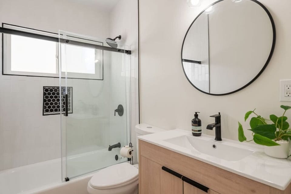 Full bathroom with vanity sink, toilet, tub, shower, and toiletries (shampoo, conditioner, body wash).