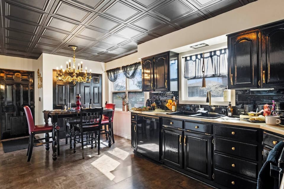 Chic & fully stocked kitchen 
Cook, sip, and gather in this elegant space featuring bold black cabinetry, gold accents, and a stunning chandelier. Perfect for family meals, wine nights, or celebrating in style. ✨