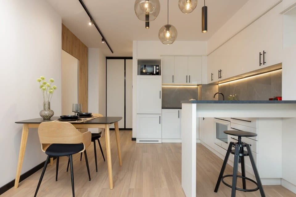 A dining corner with bar stools and a cozy atmosphere, perfect for casual meals or work.
