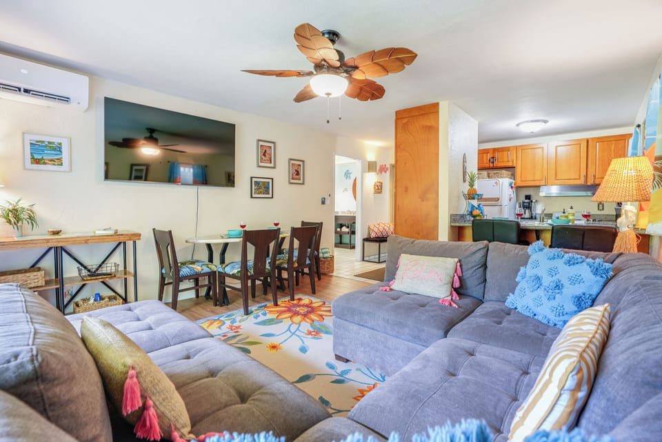 Wind down with movie night in the comfortable living room, featuring central A/C and vibrant island decor.