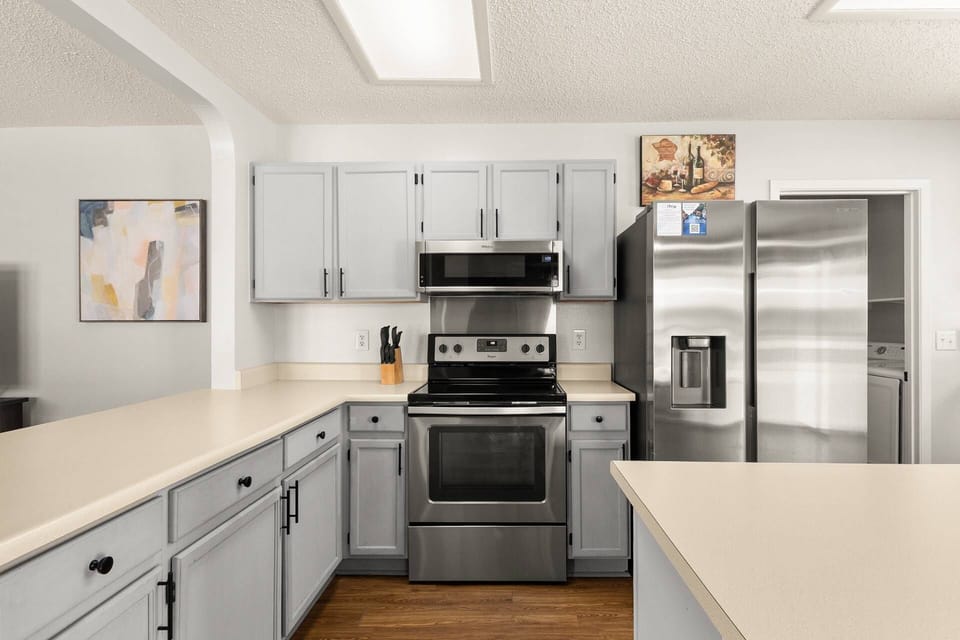 Modern kitchen with stainless appliances, microwave, oven, and plenty of counter space.