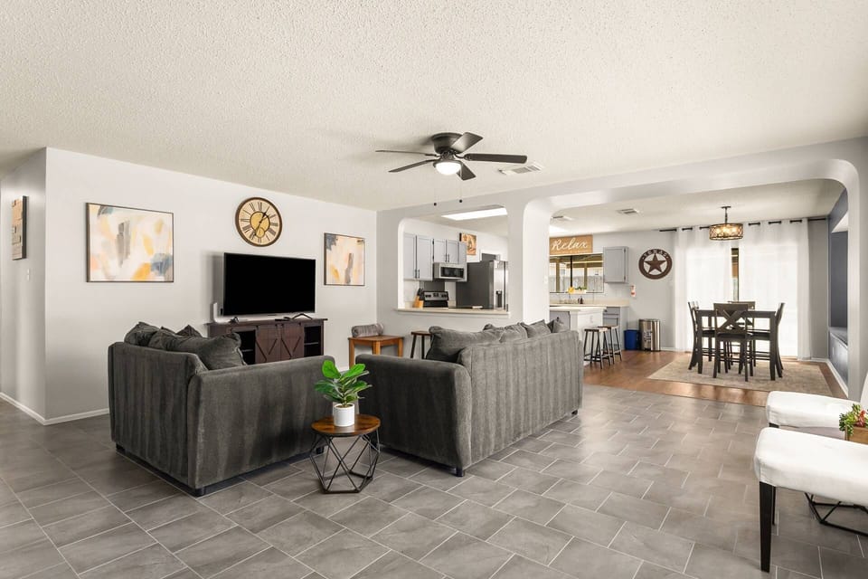 Spacious open living room with comfortable seating and TV—perfect for relaxing after a day exploring San Antonio.