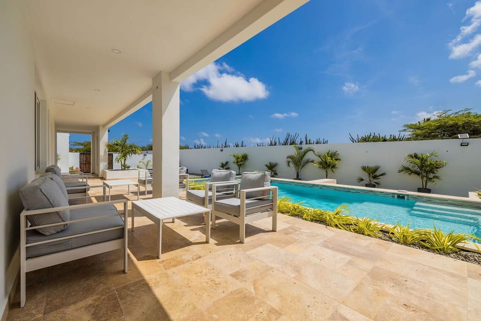 Lounge under the shade beside your private pool, surrounded by lush palms and modern comfort—a perfect spot to unwind under the tropical sun.