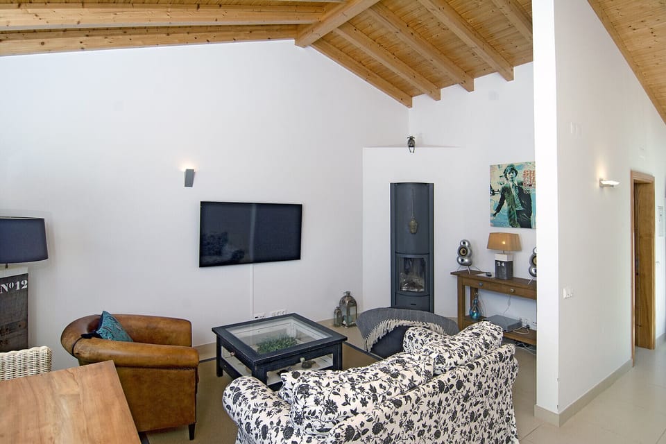 In the corner of the living room there is a walled-in fireplace.