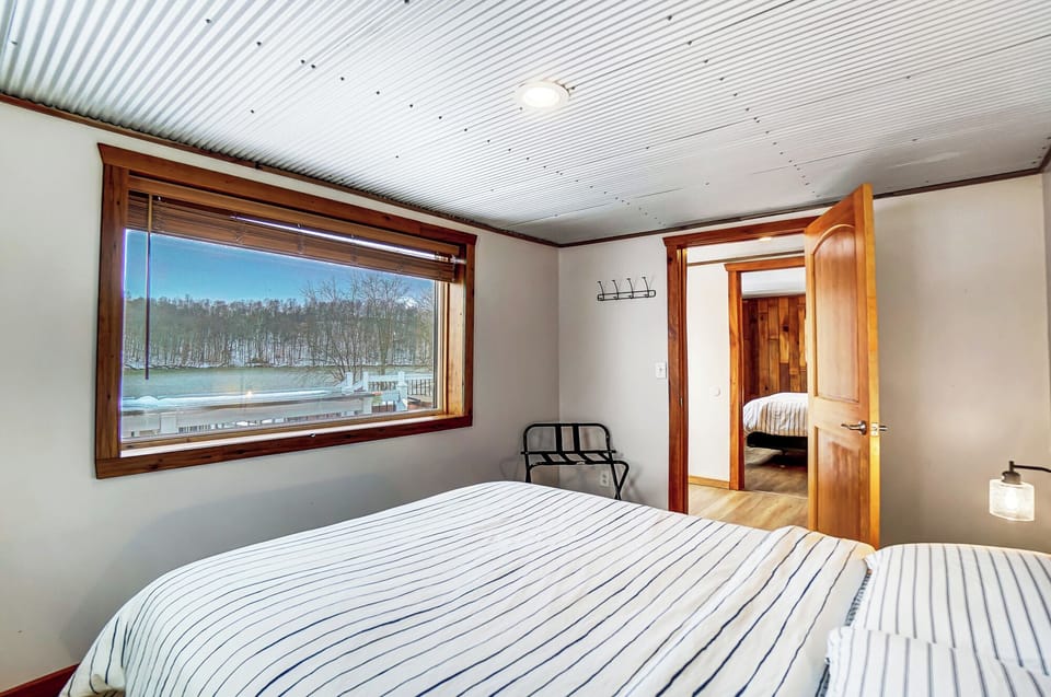 Bedroom 1 with queen bed and unobstructed lake views.