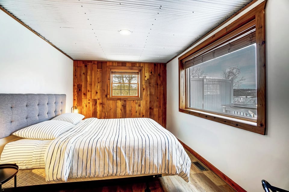 Bedroom 1 with queen bed and unobstructed lake views.