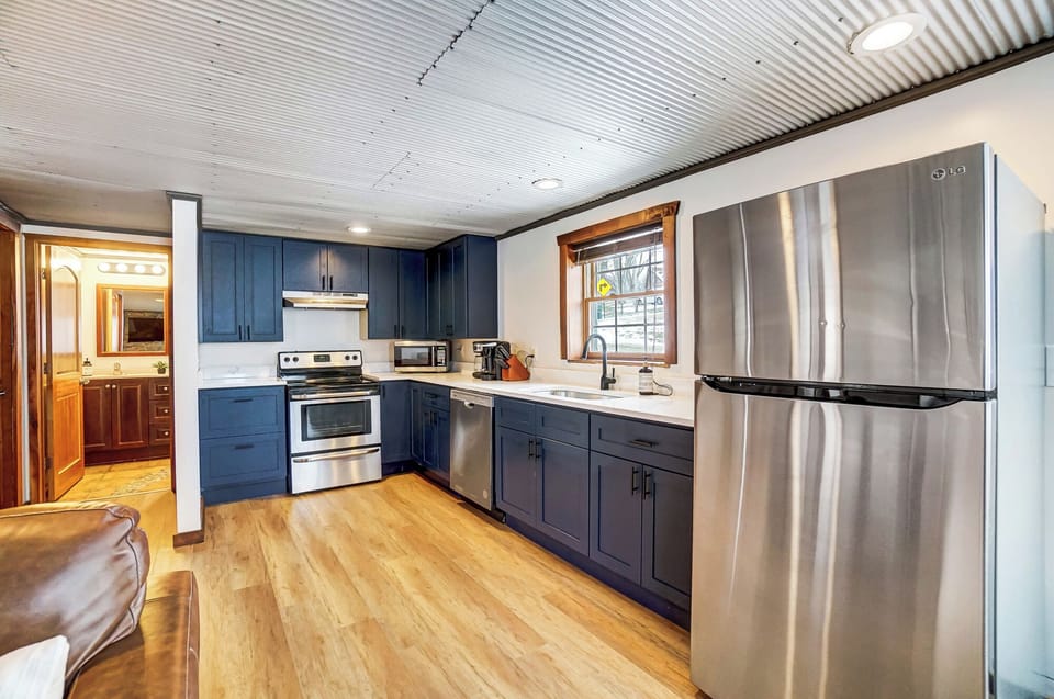 The fully equipped kitchen features quartz countertops and an electric range.