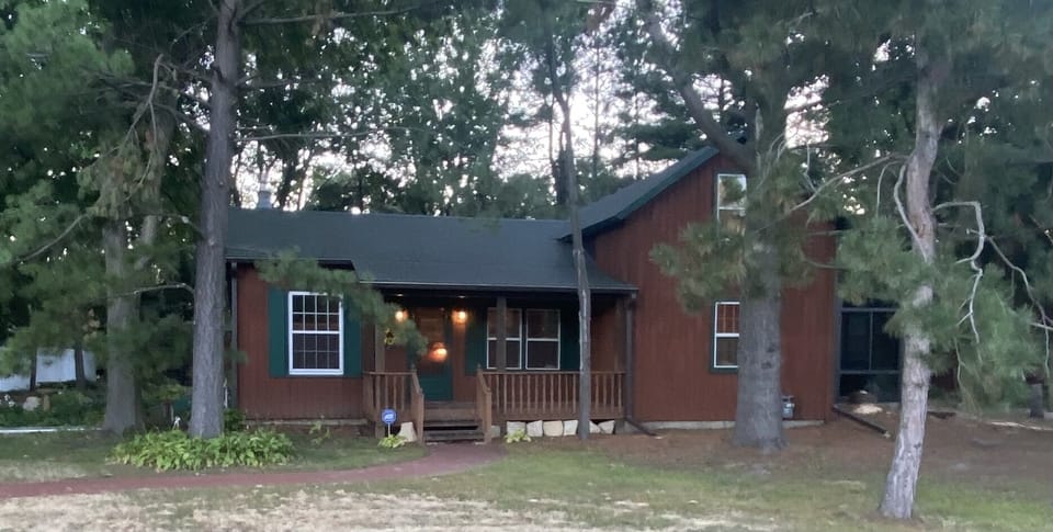 Front of home, deck with chairs to sit and relax.