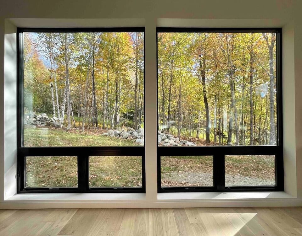 Triple-pane glass walls framing the private forest