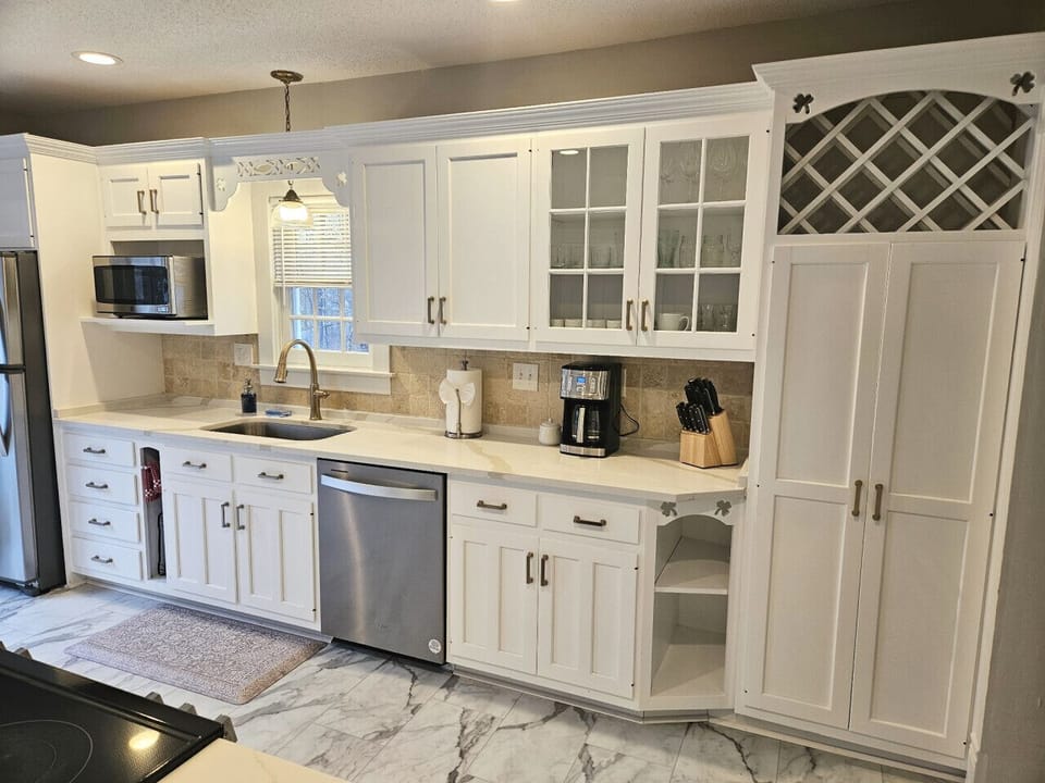 Bright, spacious kitchen featuring a large center island with seating for three—perfect for casual meals or morning coffee. Filled with natural light and modern finishes, it’s designed for both cooking and gathering.
