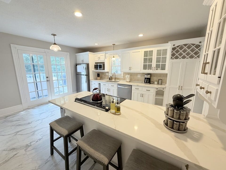 Bright, spacious kitchen featuring a large center island with seating for three—perfect for casual meals or morning coffee. Filled with natural light and modern finishes, it’s designed for both cooking and gathering.