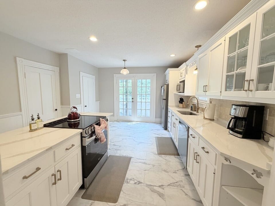 Bright, spacious kitchen featuring a large center island with seating for three—perfect for casual meals or morning coffee. Filled with natural light and modern finishes, it’s designed for both cooking and gathering.