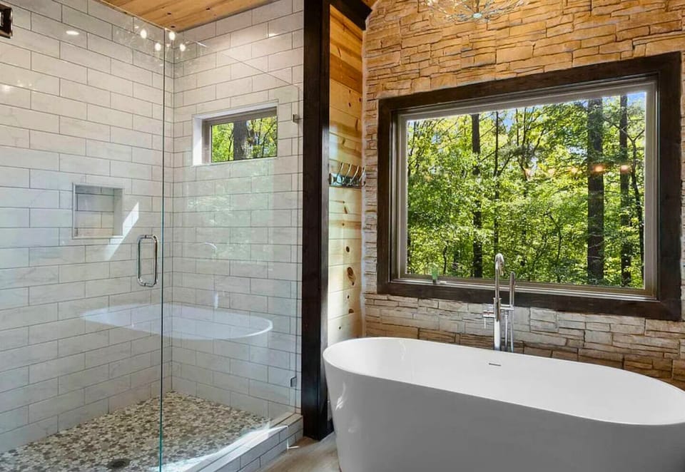 Soak up the serenity in our modern tub with a wooded view, perfect for relaxation.