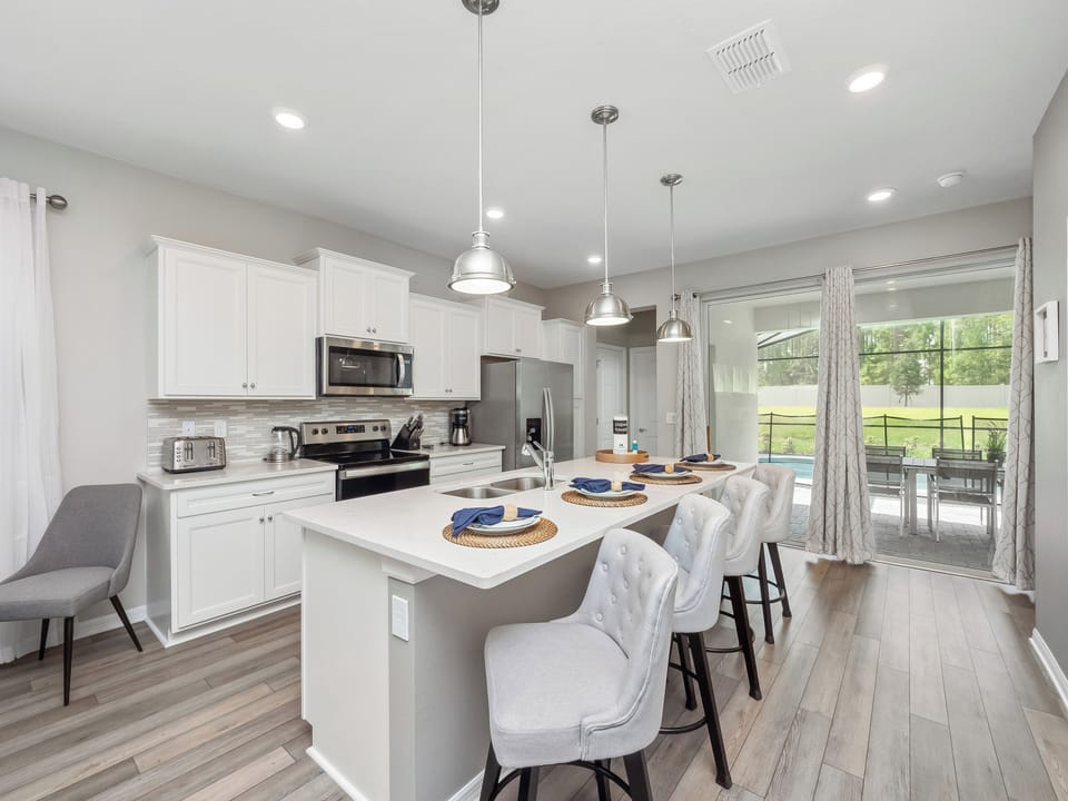 Spacious Full Size Kitchen Area with Kitchen Essentials and Barstool Seating
