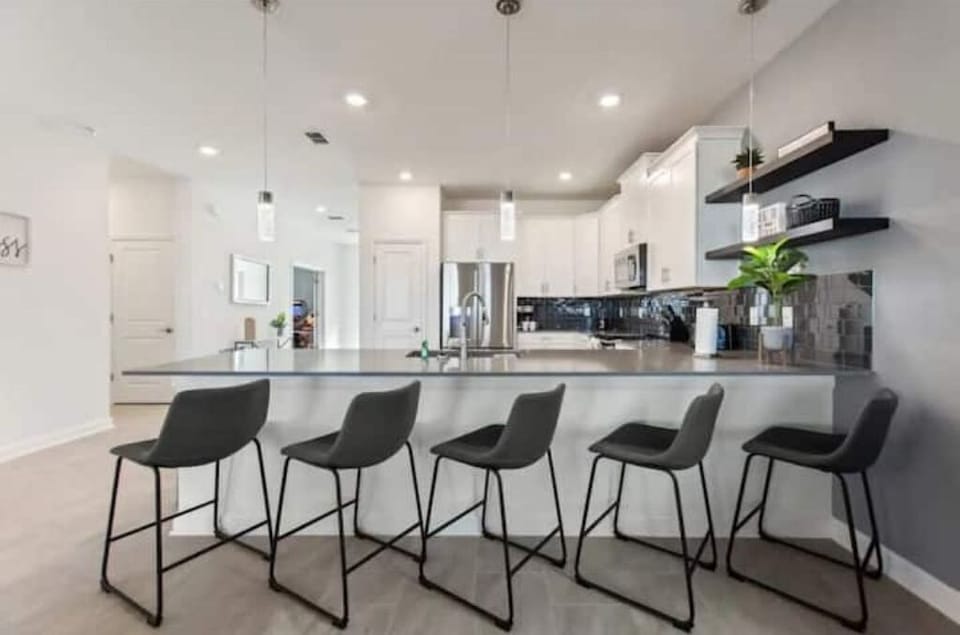 Breakfast Bar that Seats 5 People with Kitchen in Background