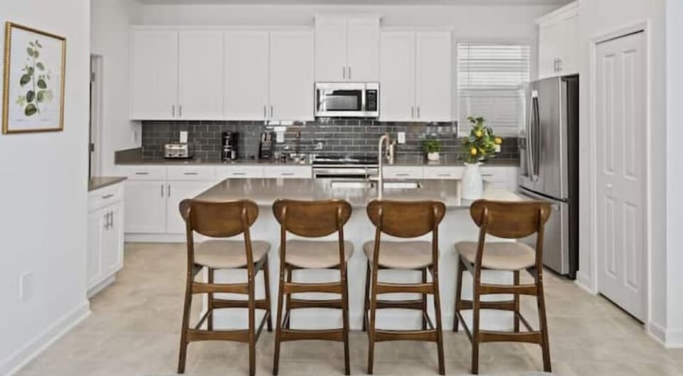 Breakfast Bar that Seats 4 People & Kitchen in Back Ground