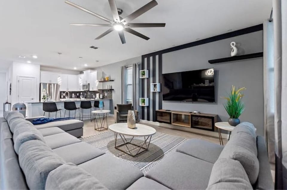 Living Room Area With TV & Kitchen Area In The Background