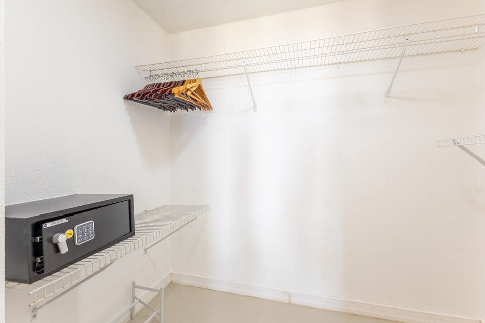 Spacious closet with ample storage, hangers, shelving, and convenient space for luggage organization.