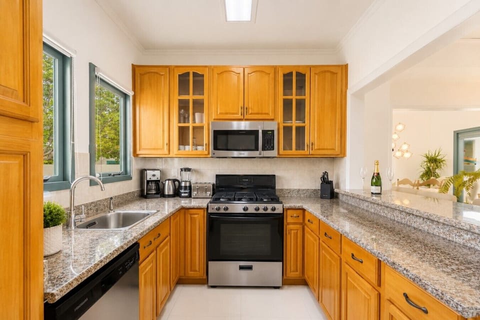 Fully equipped kitchen featuring modern appliances, cookware, essentials, and ample space for meal preparation.