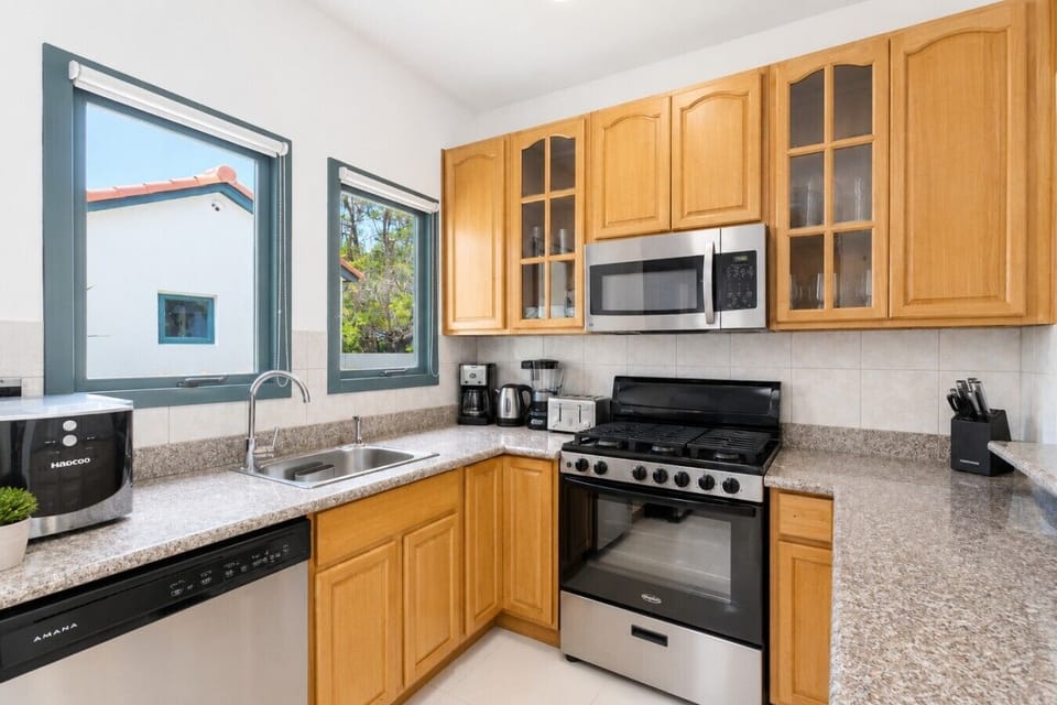 Fully equipped kitchen featuring modern appliances, cookware, essentials, and ample space for meal preparation.
