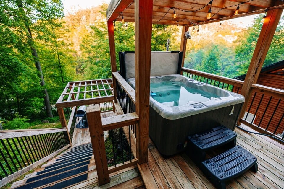Slip into the private hot tub after hiking, surrounded by trees, string lights, and peaceful mountain views