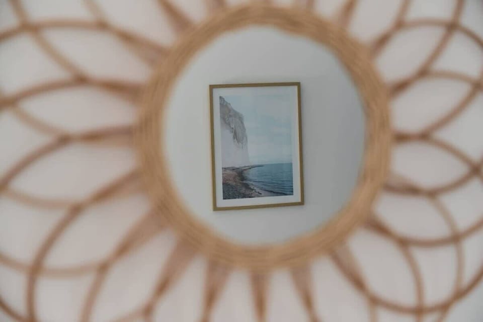 A close-up of a decorative round mirror, reflecting the thoughtful design of the space.
