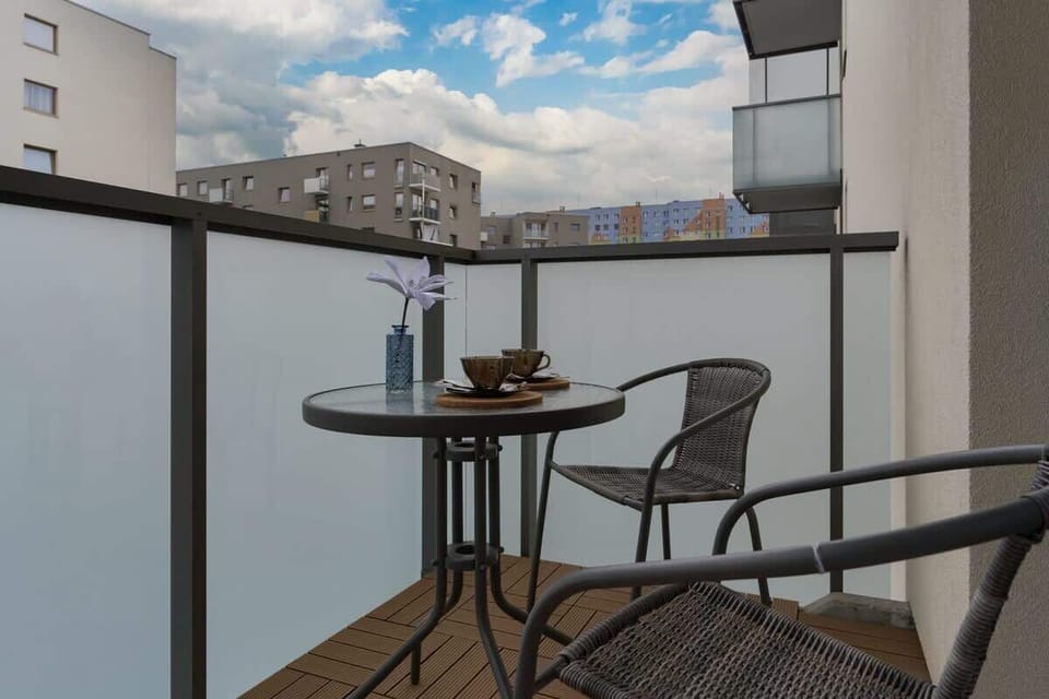 A balcony setup with a small table and chairs, perfect for enjoying coffee or a meal outdoors.
