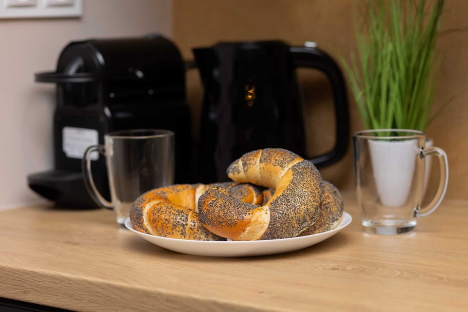 A close-up of the kitchen counter with a coffee maker, mug, and a fresh croissant, creating a homely vibe.
