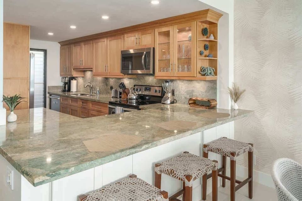 Cook and dine in style! This kitchen boasts gorgeous light green granite countertops and a comfy breakfast bar.