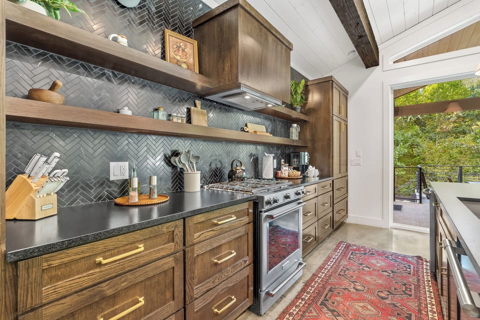 Kitchen: Elegantly designed space with modern appliances and a vibrant rug overlooking lush views!