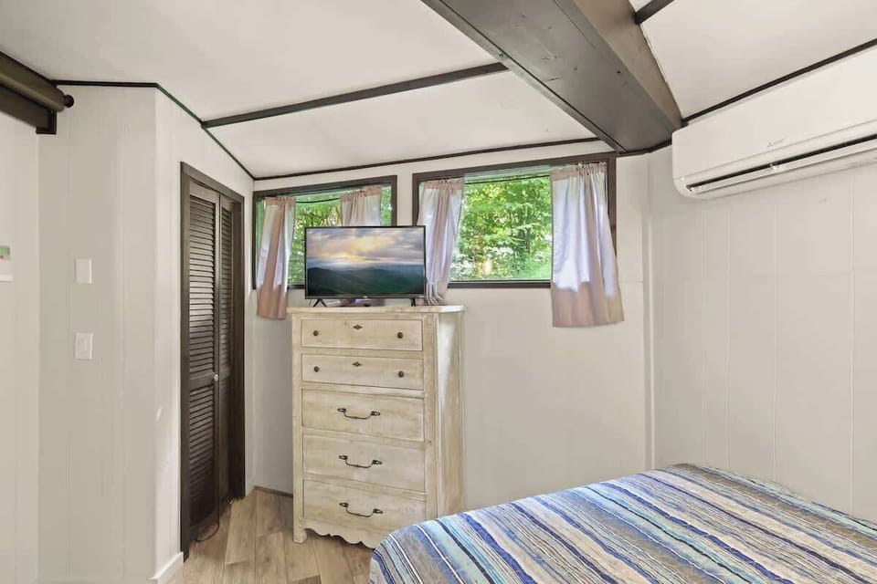 Discover comfort with a queen bed, TV, and plenty of chest drawer space, creating a relaxing bedroom ambiance.