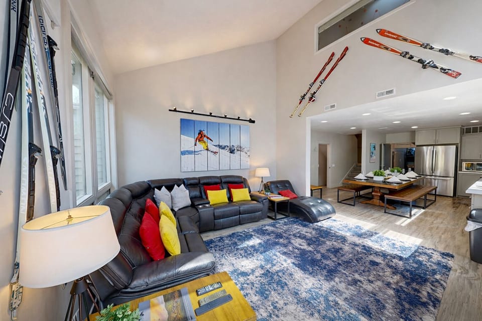 Relax in your spacious living area with plush sectional seating, ski-themed decor, and an open kitchen perfect for après-ski gatherings.