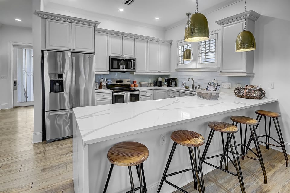 First Floor Kitchen with four stools at the kitchen counter. Entertain in style while your family and friends are perched at the kitchen counter—where conversations flow and culinary adventures begin.