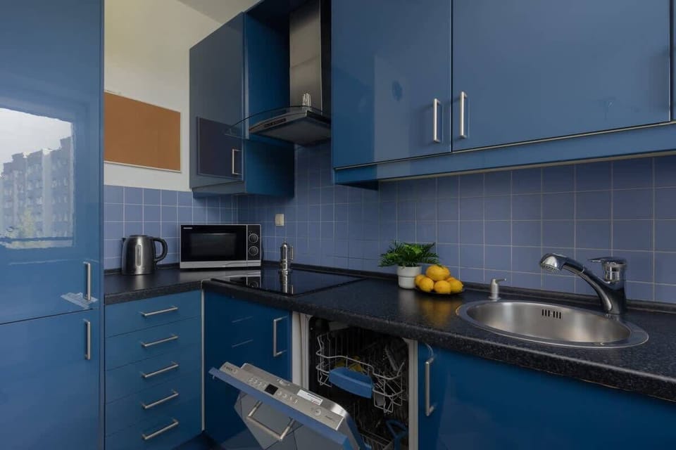 A detailed look at the kitchen from another angle, showcasing its spacious countertop, stylish blue cabinets, and a well-organized layout.







