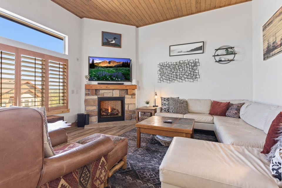 Bear Hollow Village 5595: Cozy sofa set by fireplace, framed by a picturesque window view.