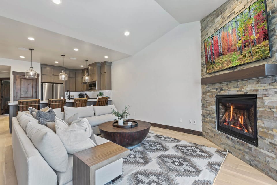 Curl up on the plush sofa with a good book as the fireplace crackles warmly, casting a cozy glow across your inviting open-concept living space.