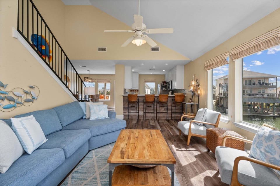 Stylish living space with vaulted ceilings, modern furnishings, and waterfront ambiance.