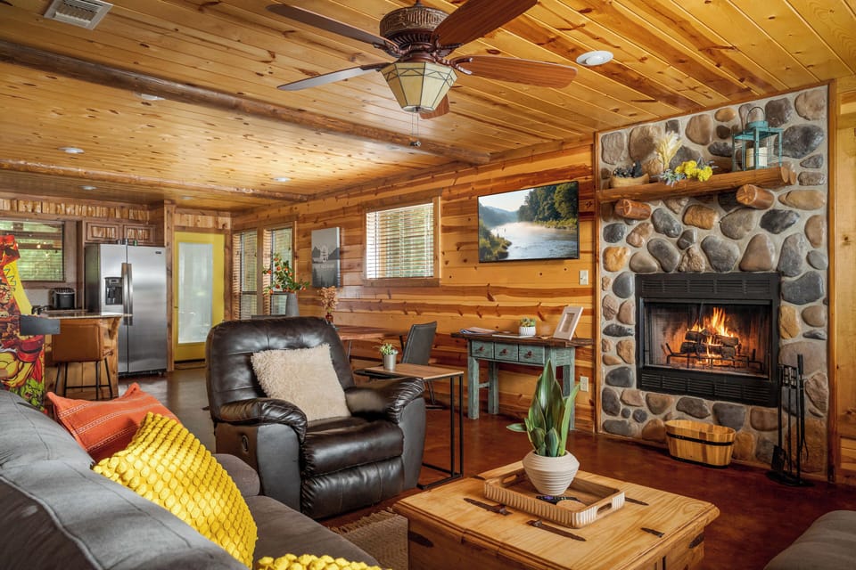 Open-concept living space with beautiful stone fireplace and comfy seating.