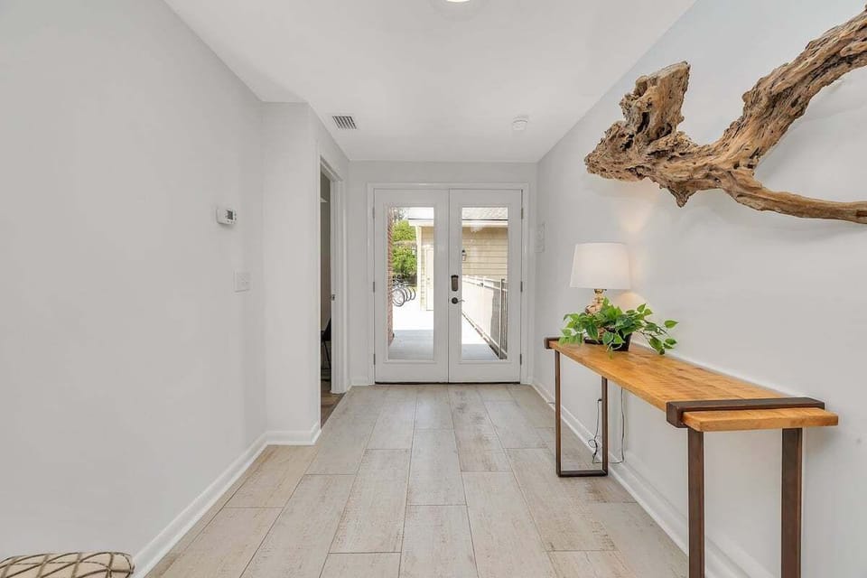 Entryway hallway with wood console table and French doors