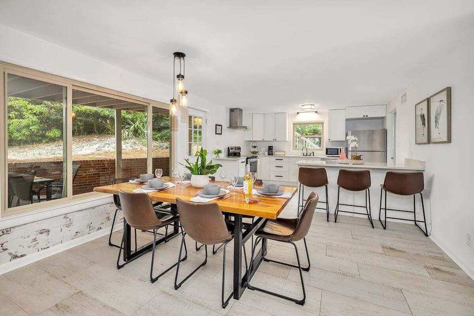 Dining area with long wood table and pendant lights