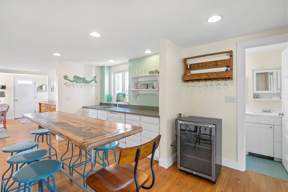 View of the kitchen and 1st floor full bathroom with standing shower.  There is a wine fridge and dishwasher, along with plenty of dishes, glasses, cu