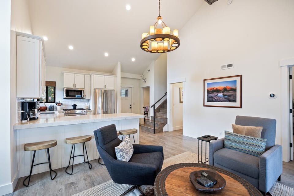 Spacious and airy open floor plan seamlessly connecting the living room and kitchen. Comfortable seating and contemporary finishes offer a welcoming space for entertaining or family gatherings.