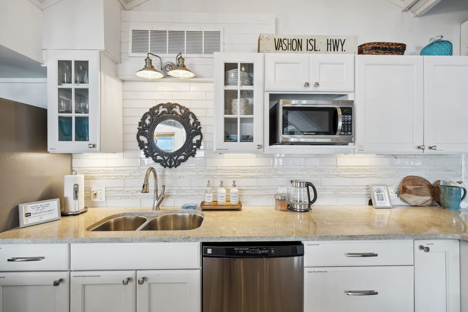The kitchen cabinets adorned in a crisp, glossy white finish, spans the walls in a seamless, offering ample storage while maintaining a clean, uncluttered look. 