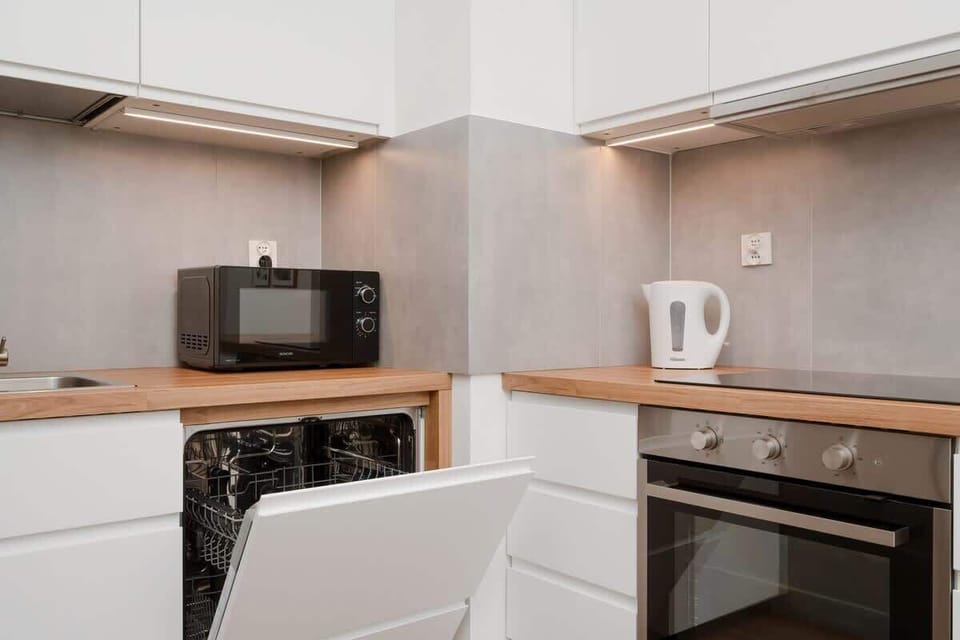 A kitchen detail with a wooden countertop, a microwave, and minimalist decor for a clean aesthetic.



