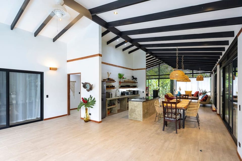 Open-concept living, dining, and kitchen area with high ceilings and spacious layout in Puerto Viejo, Casa Kali