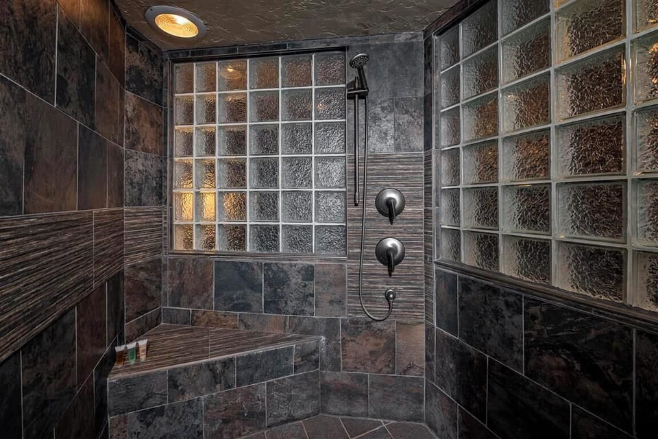 Unique bathroom with dark tiled shower for a rustic touch.