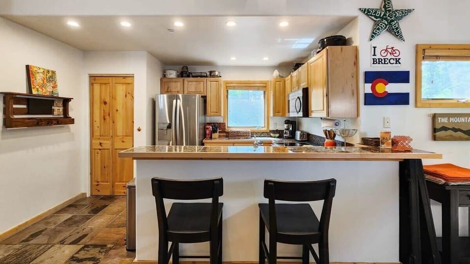 The kitchen includes a kitchen bar with two bar stools providing a great additional seating option for hanging out or eating.