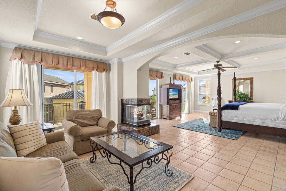 Relax in your luxurious master suite with elegant furnishings, warm fireplace, and comfortable seating area creating the perfect retreat.