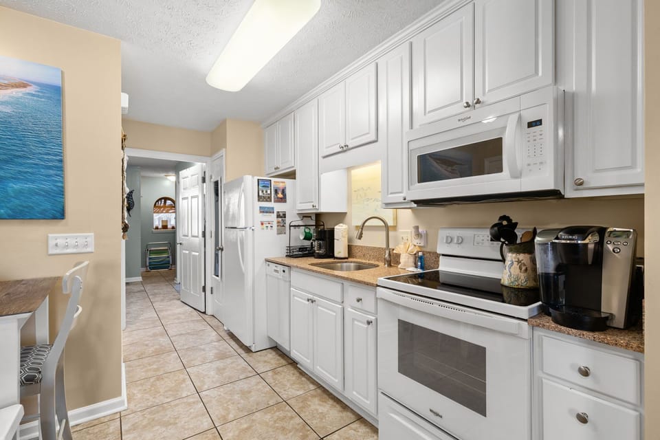 modern kitchen with white cabinetry and full appliances